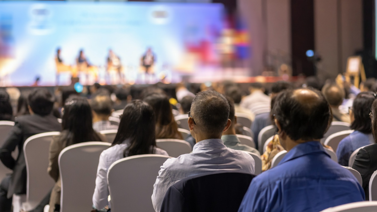 Large room of people listening to a presenter