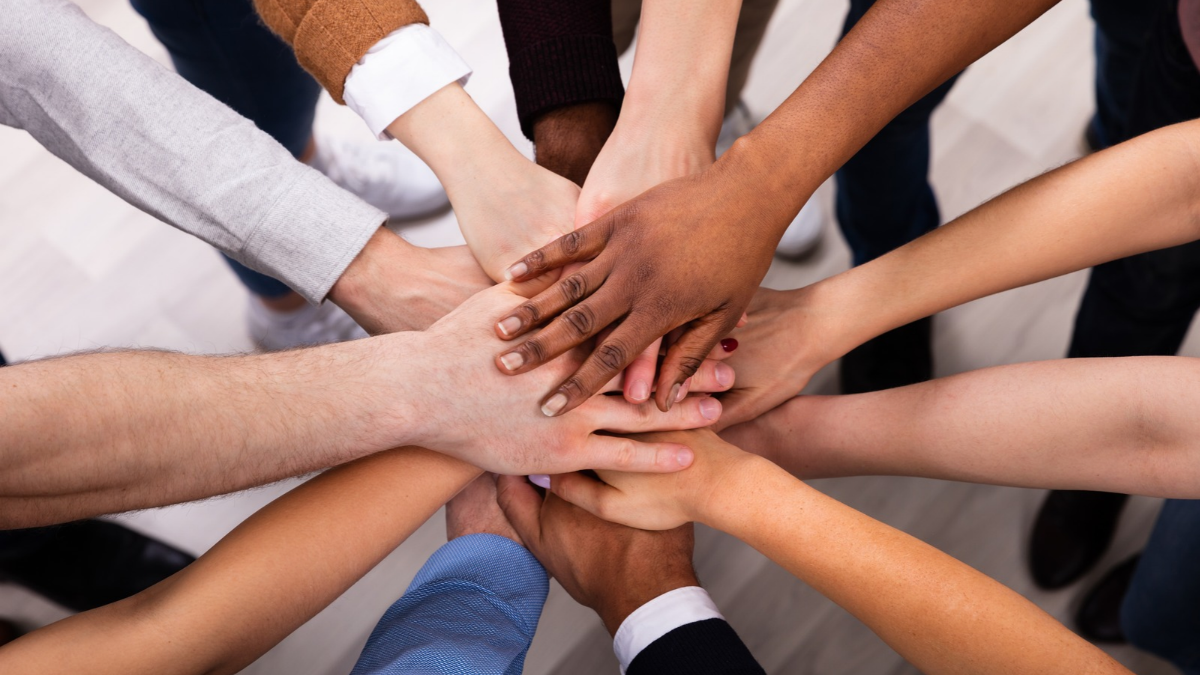 People stacking hands on top of one another