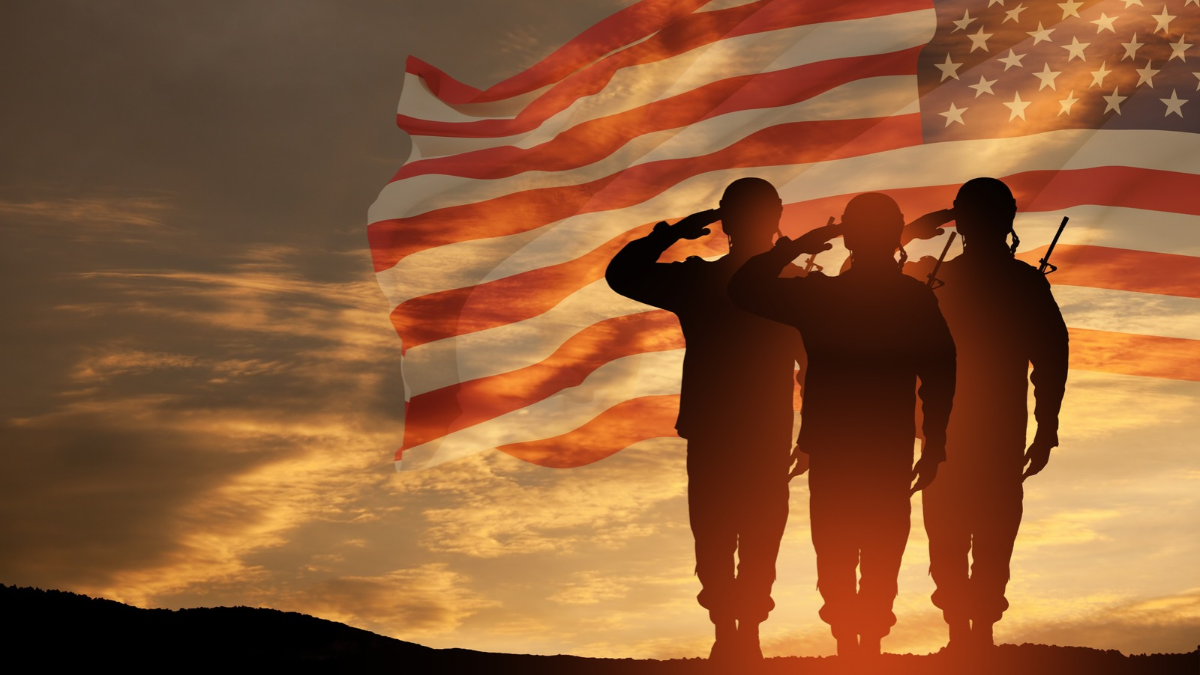 Military men saluting the American flag