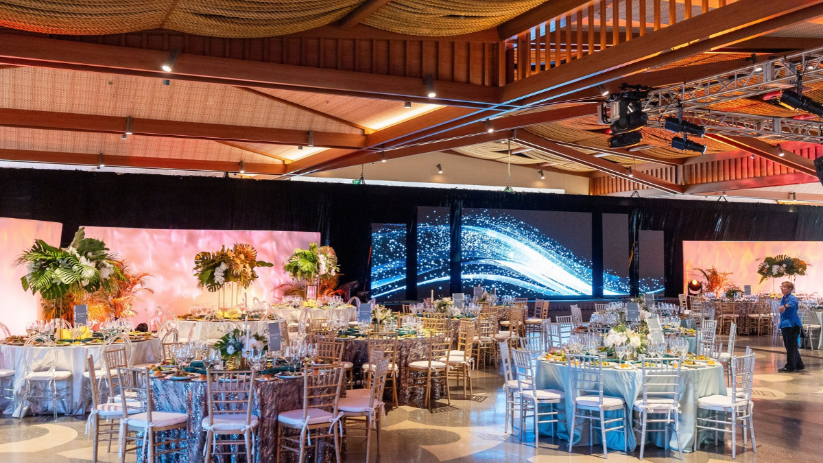 Ball room with tables and a production screen