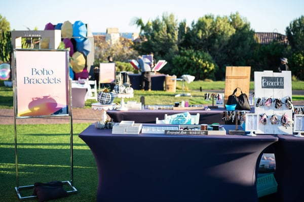 Outdoor activity station with tables, signage, and interactive displays set on a lawn.