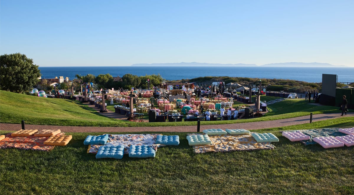 Outdoor event setup on a grassy hill overlooking the ocean