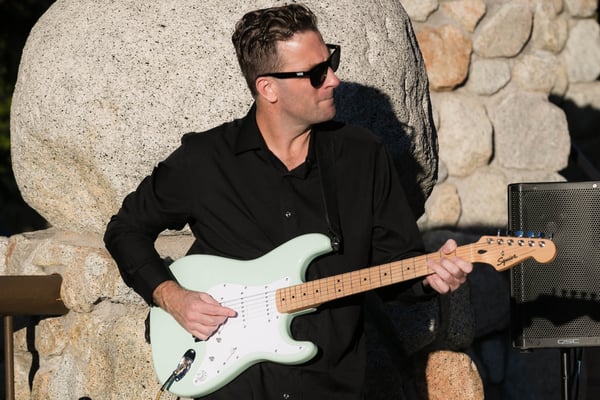 Musician performing at a lakeside event. 