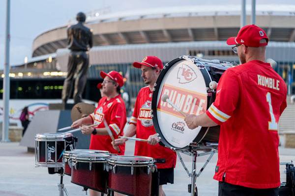 Drumline performing outside a stadium. 