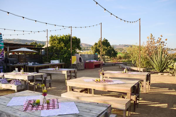 Outdoor lounge seating with cushions and string lights in a relaxed event setting.