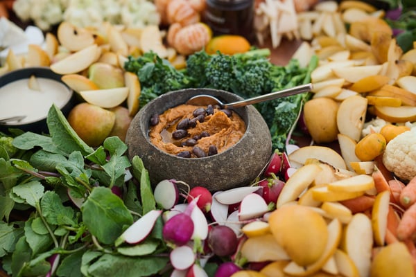 Close-up of a charcuterie-style spread with fresh vegetables, dips, and bread.