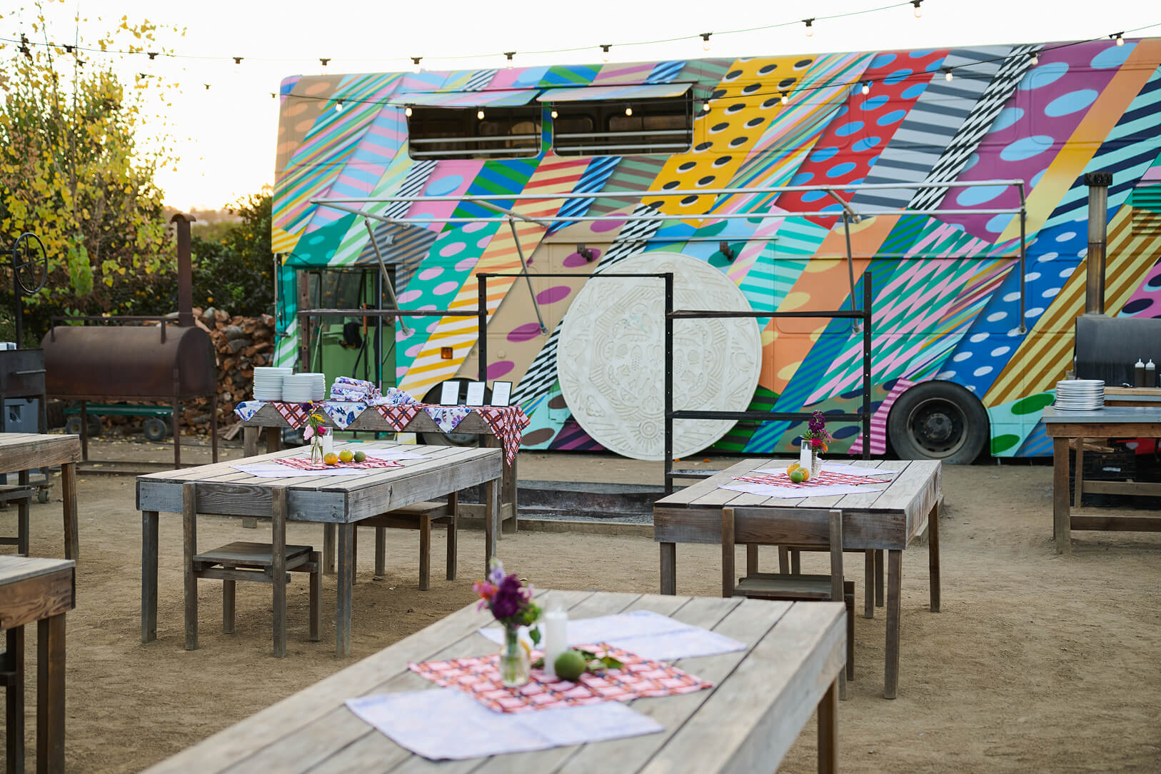 Colorful outdoor lounge with painted structures and seating in a creative event space.
