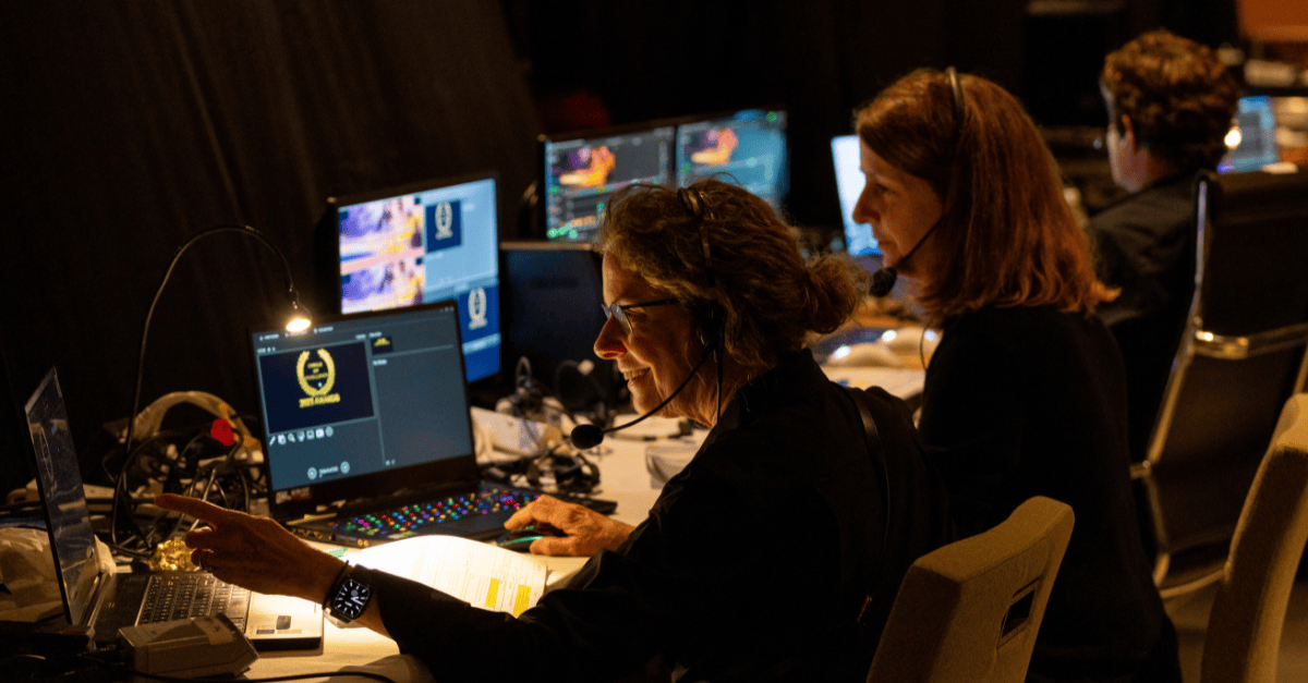 Event production team monitors screens backstage.