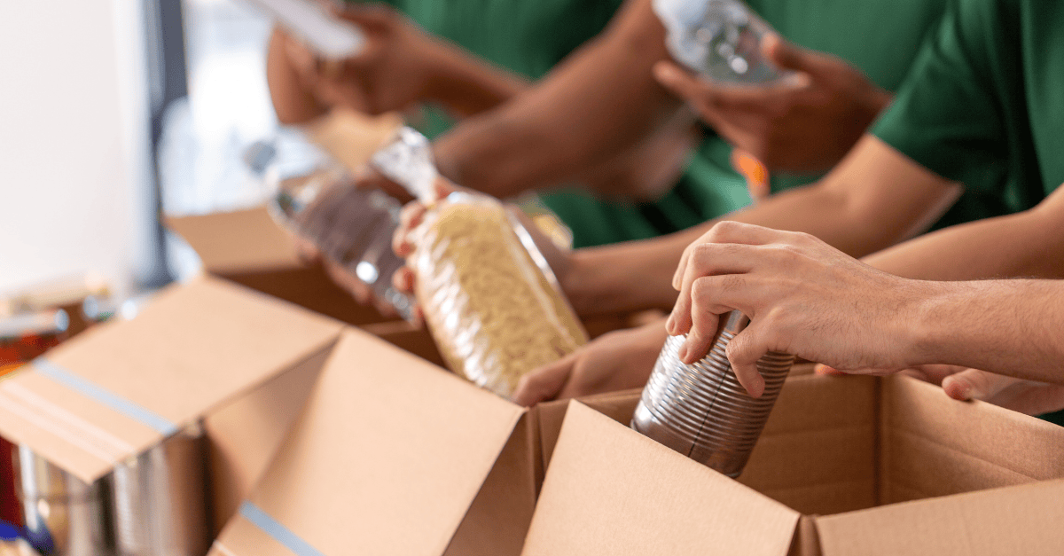Volunteers pack donated food into boxes.