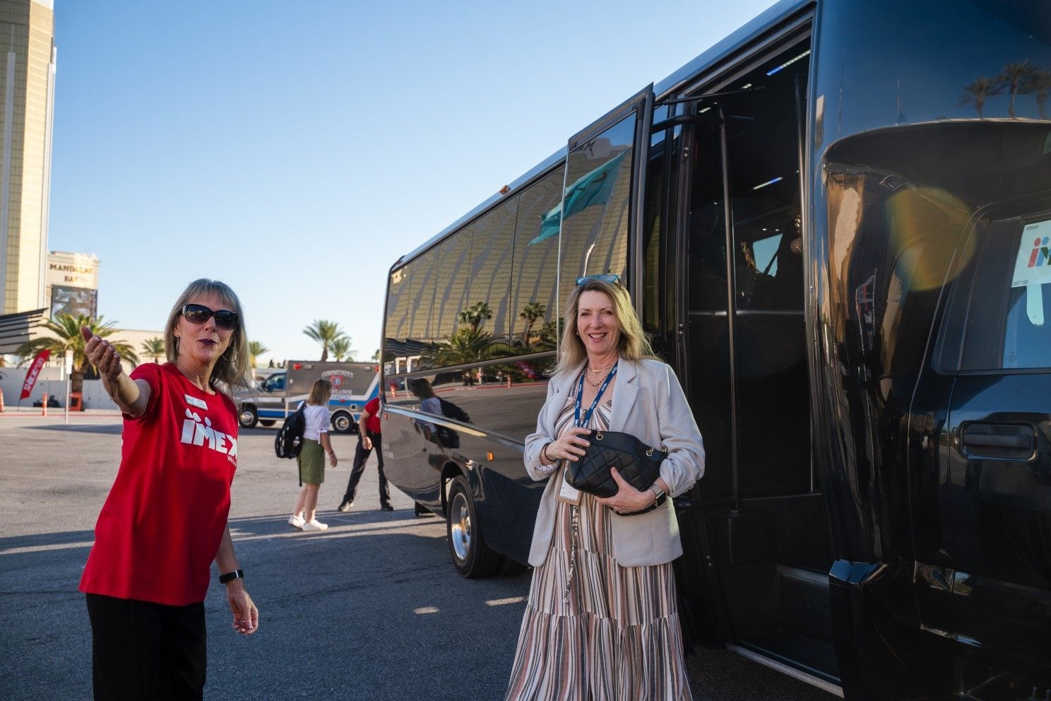IMEX team member welcomes an attendee to a shuttle.