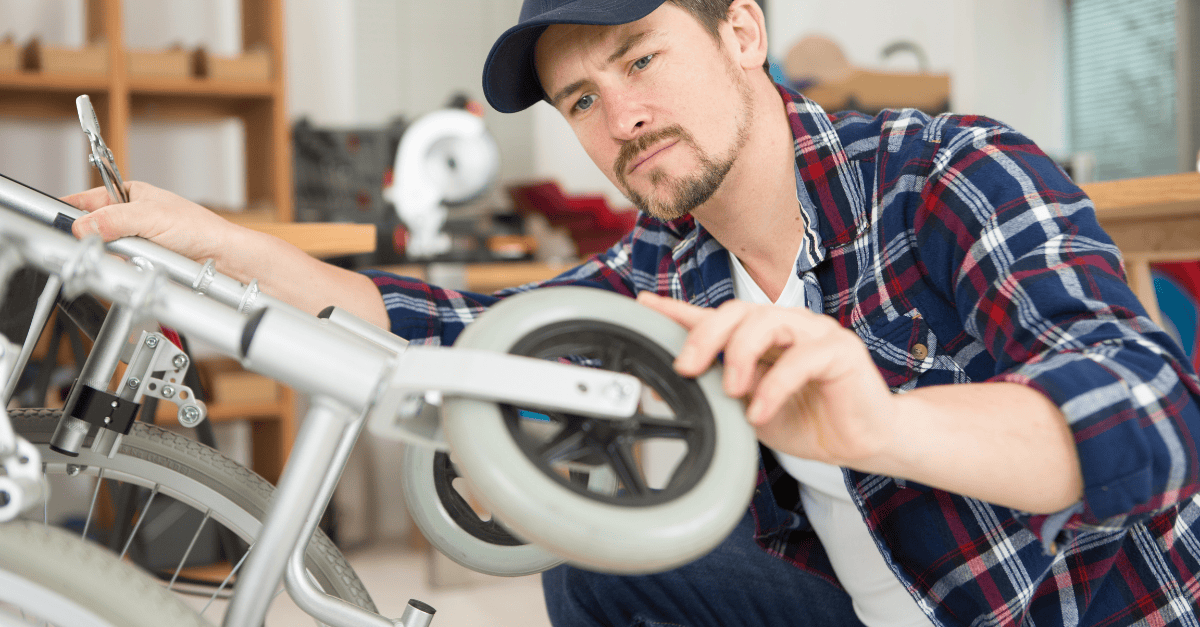 Volunteer repairs a mobility aid in a workshop.
