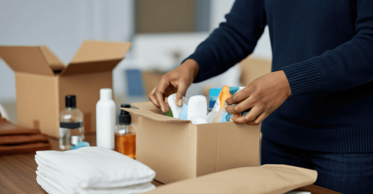 Volunteer packs personal care supplies into a box.