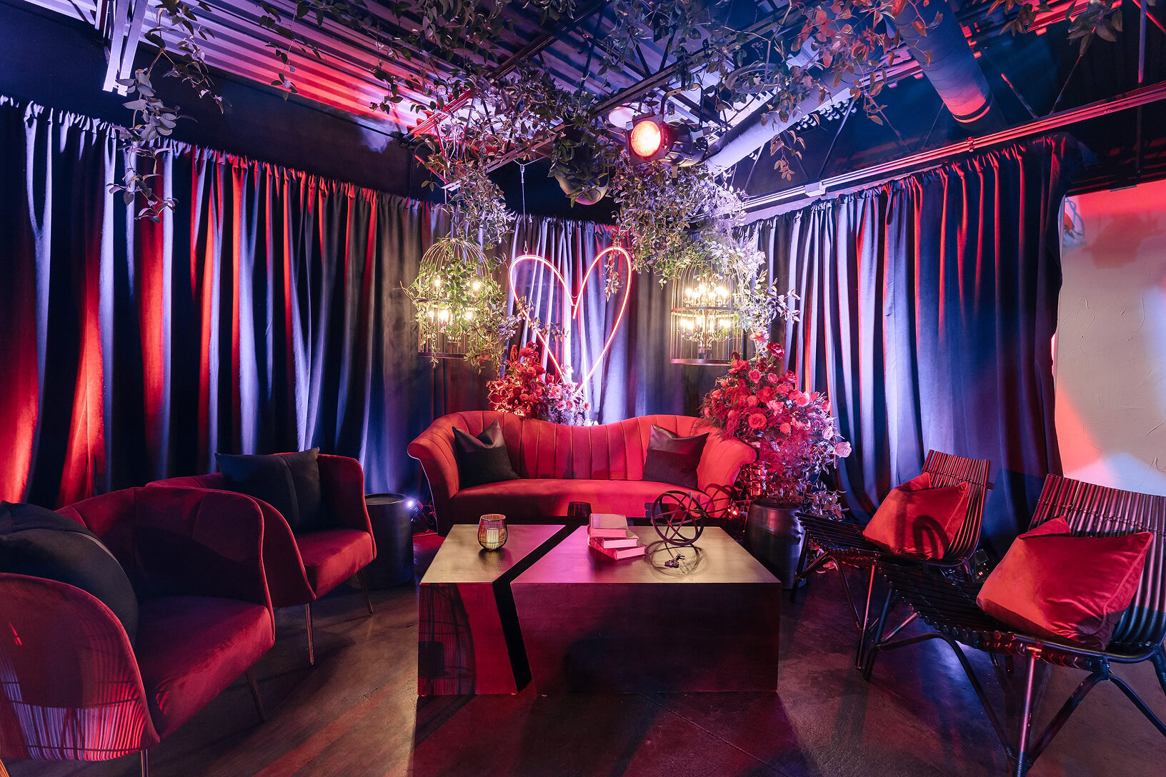 Intimate red lounge with floral décor and neon heart lighting.