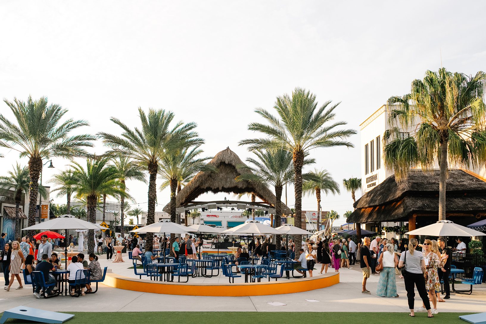 Maritz Activate guests mingle across the palm-lined plaza at The Promenade at Sunset Walk during the daytime block party.