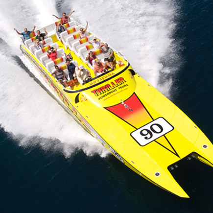 Group of people holding up their hands on a yellow speedboat during a powerboat tour on the ocean